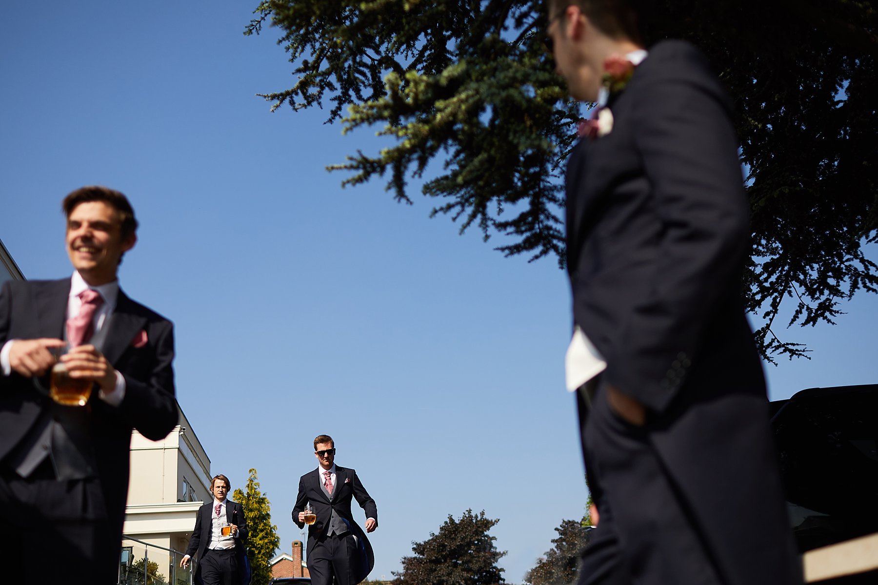 groomsmen walking in front of hotel